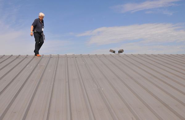 An inspector walks a hail-damaged metal roof on a municipal building in Moore, Oklahoma, May 2010