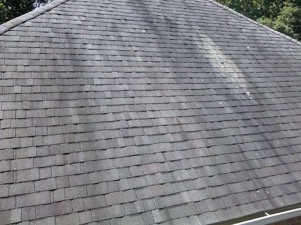 Dark vertical streaks of algae on a gray asphalt shingle roof